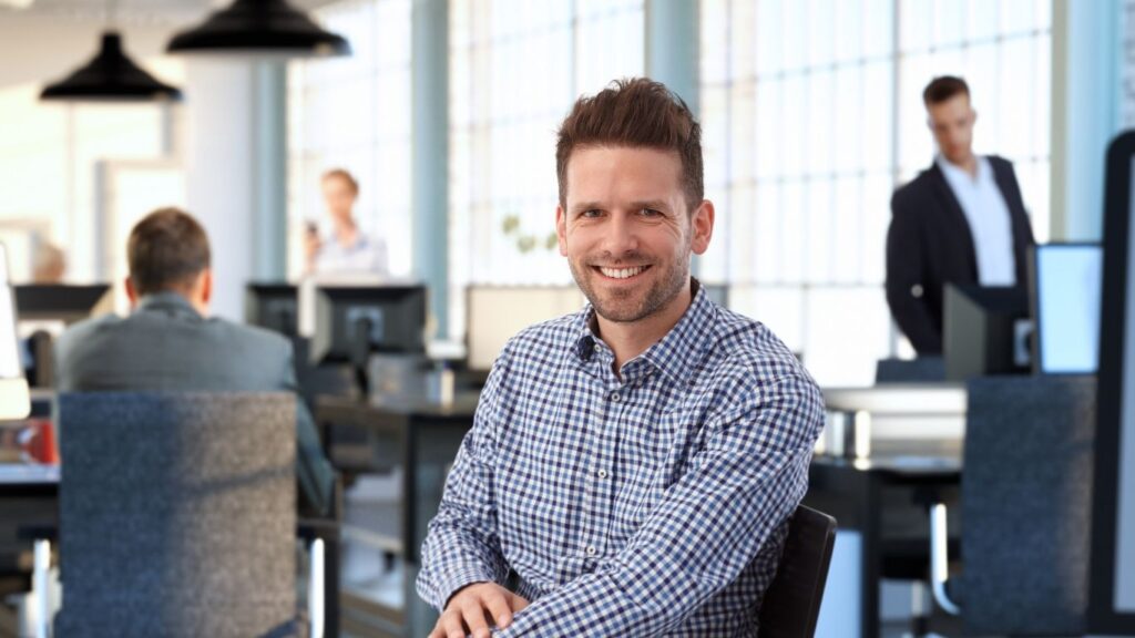 Man sitting at a desk smiling