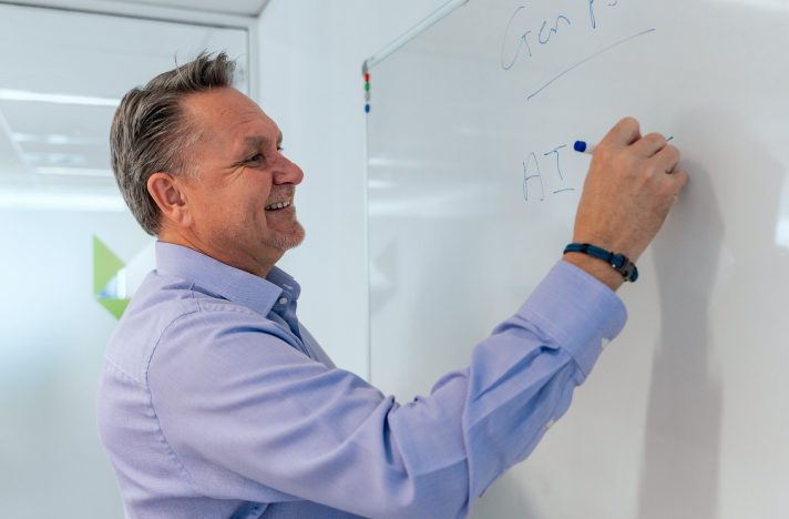A Zetta consultant writing on a whiteboard in the Perth office