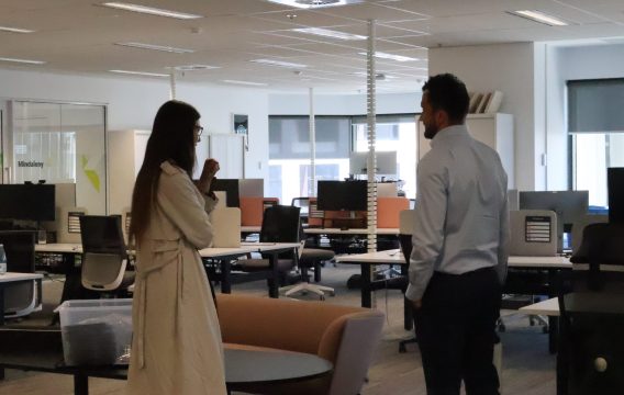 Two Zetta team members talking in the open-plan Perth office between hot desks
