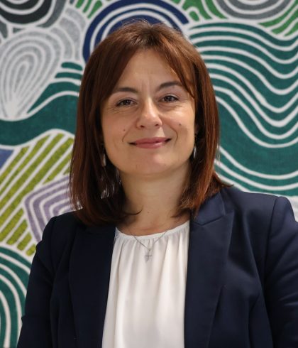 Vesna Van Biljon, Zetta Financial Controller, smiling in front of Aboriginal artwork in the Perth office